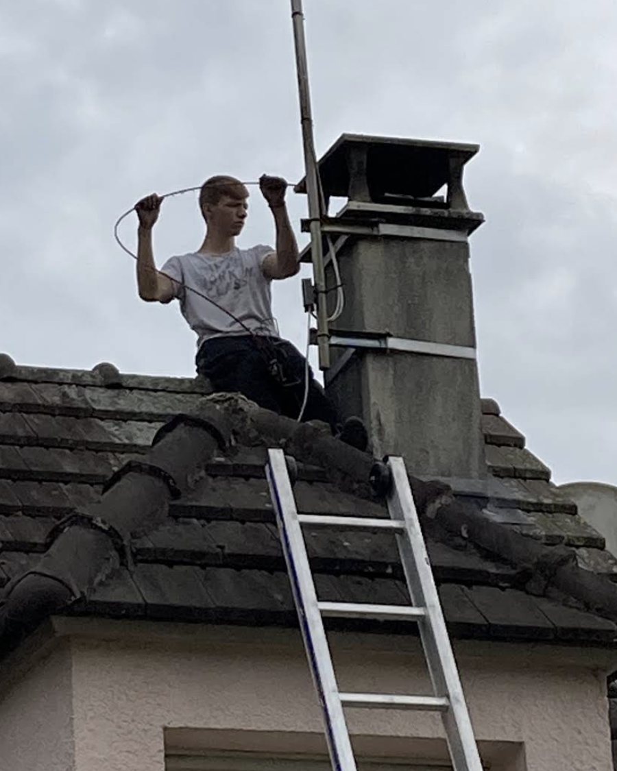 L'artisan Beautour sur le faîtage d'une maison de Seine-et-Marne, échelle de toit posée le long de la souche